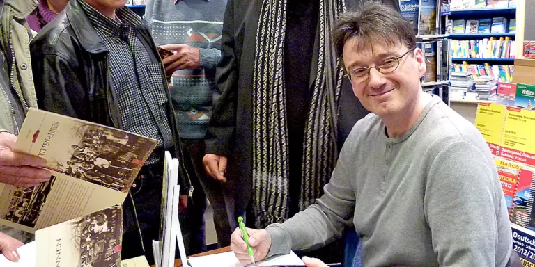 Christian Lukas signiert Bücher nach seiner Lesung in Witten. (Foto: Marek Schirmer)