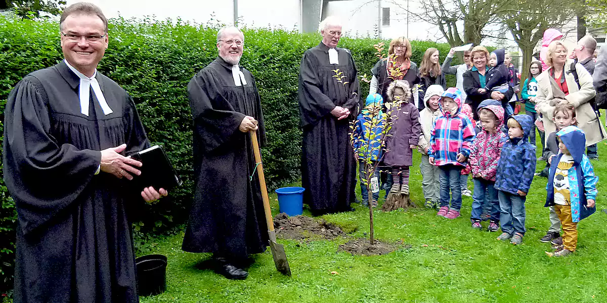 Pfarrer Gerwin Rooch pflanzt eine Baum an der Ev. Kirche in Witten-Stockum (Foto: Marek Schirmer)