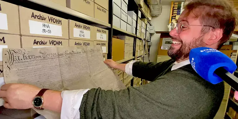 Prof. Dr. Hiram Kümper, 1. Vorsitzender des Vereins für Orts- und Heimatkunde in der Grafschaft Mark zeigt eine alte Urkunde im Archiv. (Foto: Marek Schirmer)